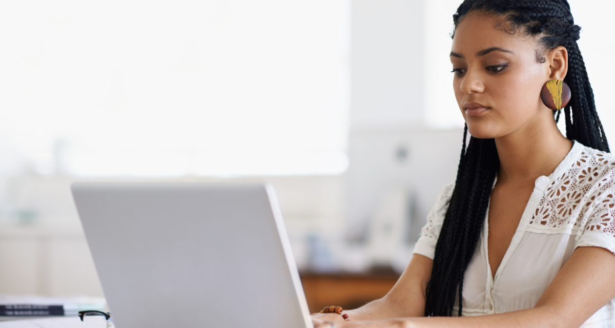 Woman facing laptop and typing